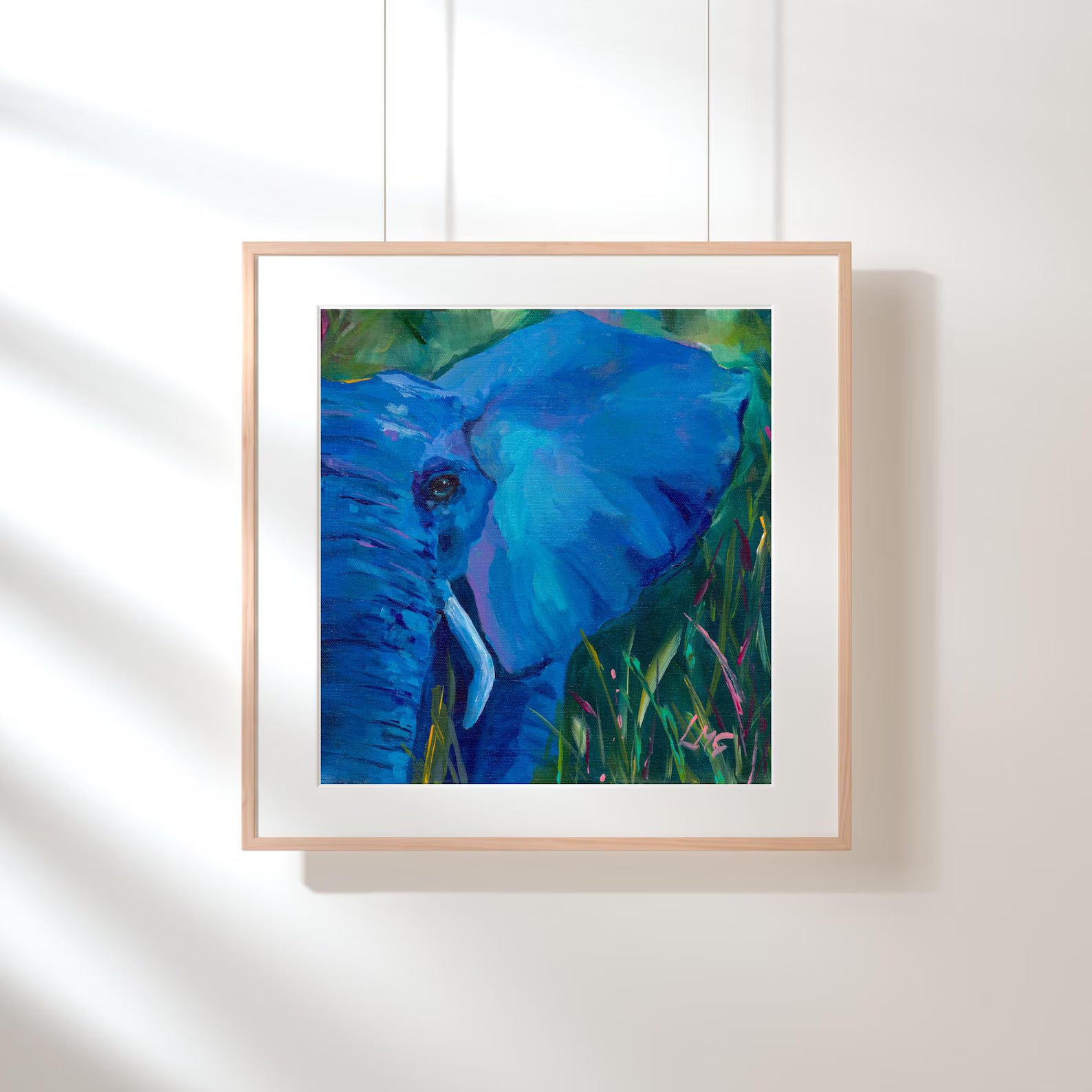Framed painting of a blue elephant on a white wall