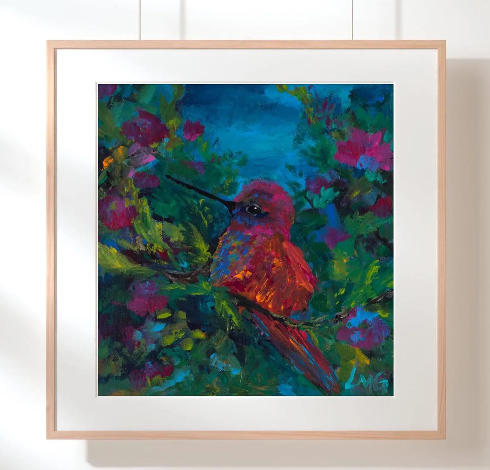 Framed painting of a colorful hummingbird on a branch with flowers