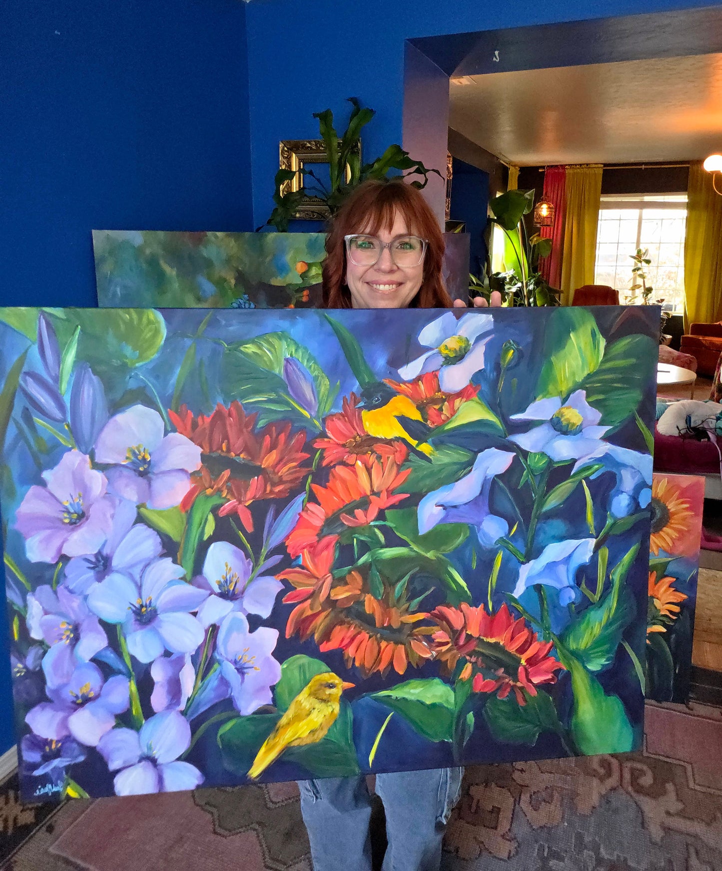 Leah MArie holding original floral and bird painting “Simple Joys,” vibrant hand-painted artwork inspired by peaceful garden moments