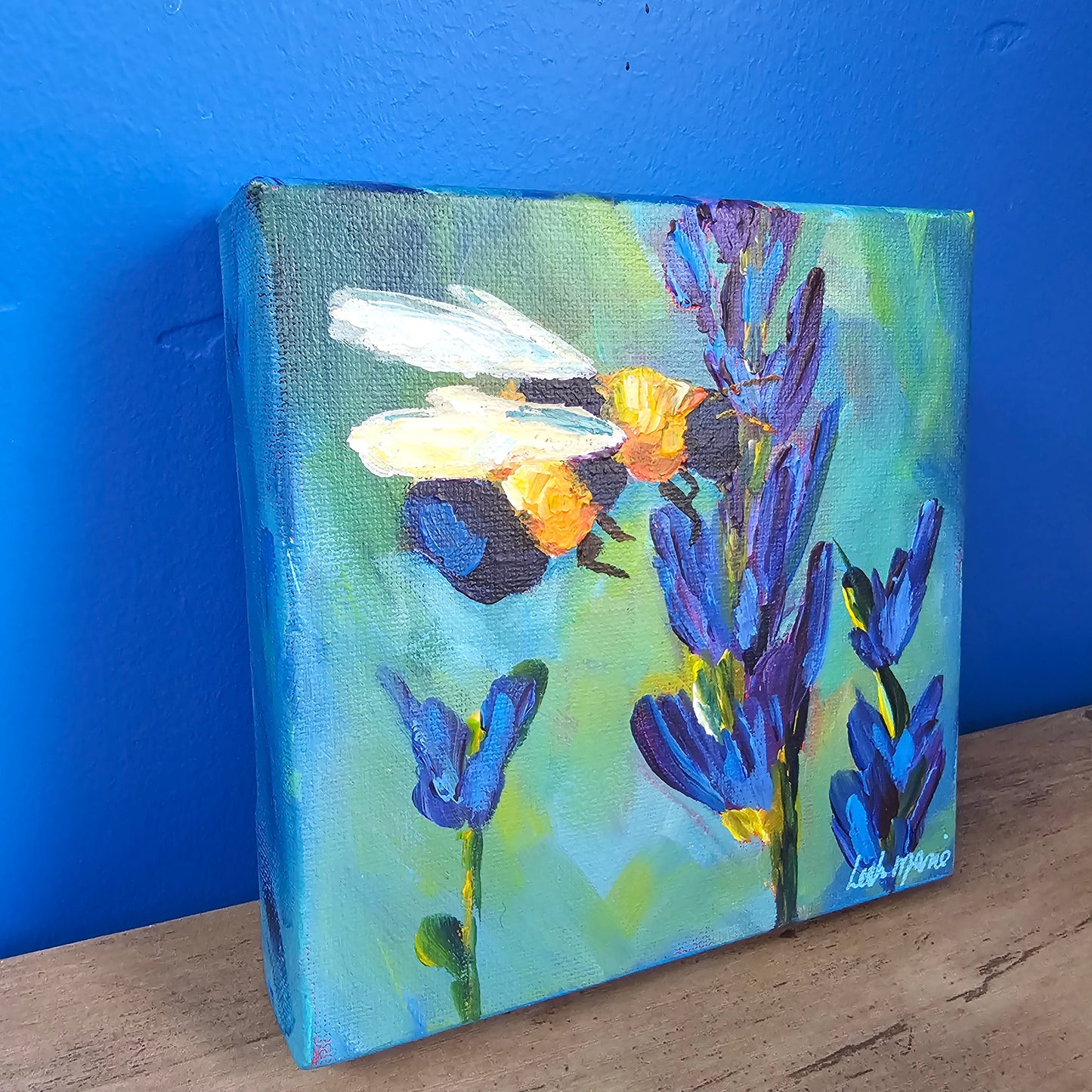 Close-up of hand-painted bee artwork with luminous petals and bold, dopamine-rich color palette on canvas.