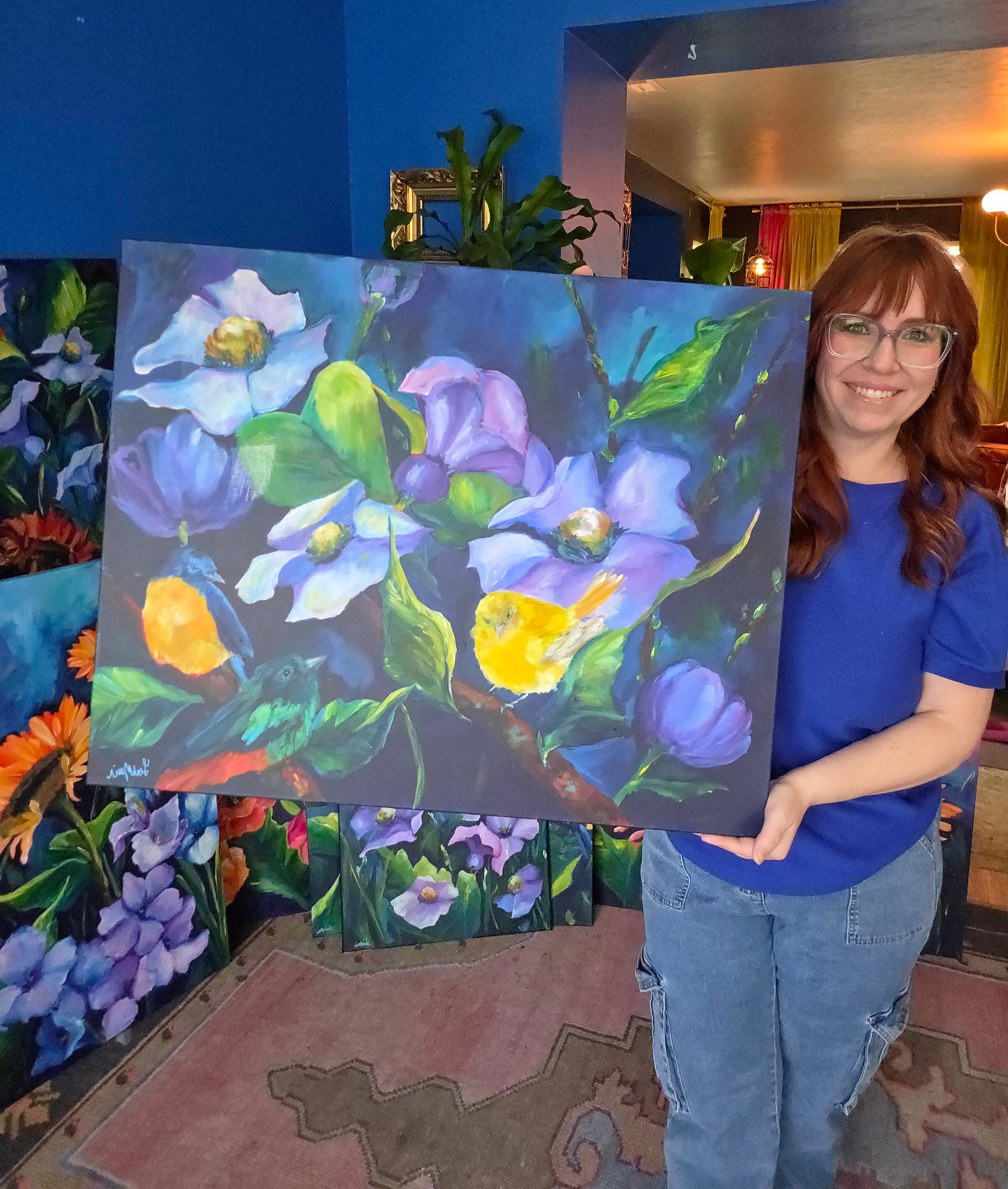 dopamine artist leah marie holding original floral and bird painting “Music of Spring,” vibrant hand-painted artwork inspired by joyful spring garden moments
