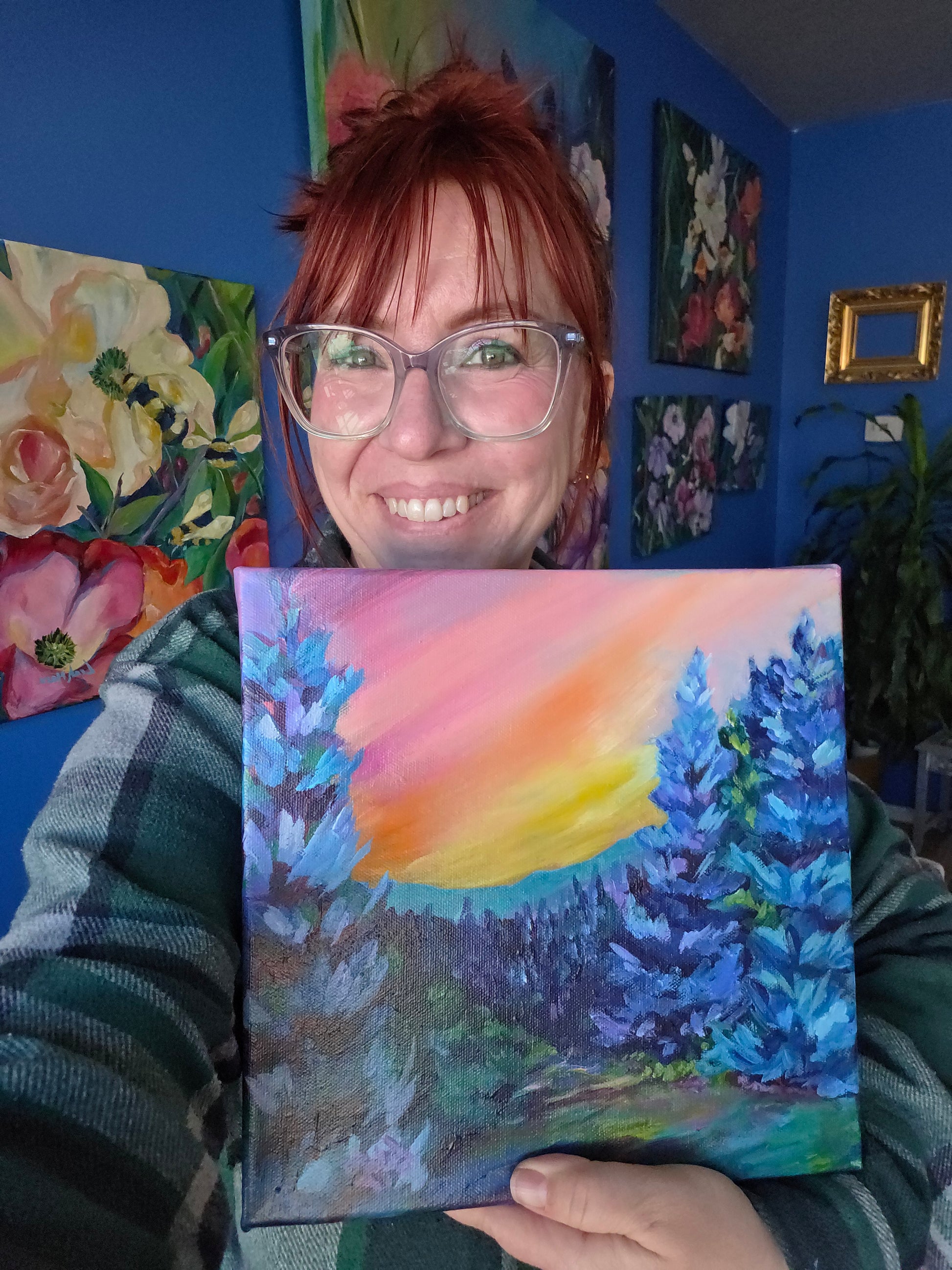 dopamine artist leah marie holding her bold vibrant landscape paiting of an idaho landscape